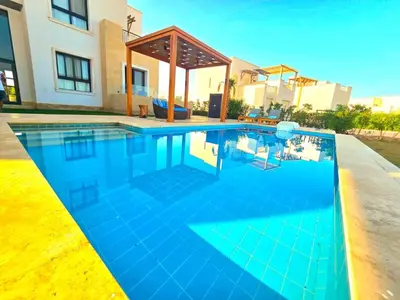 a swimming pool in a house with blue water at El Gouna Cyan the Range 4BDs Villa with private Pool in Hurghada