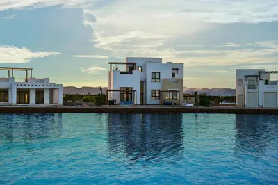 two white buildings next to a large body of water at El Gouna Cyan the Range 4BDs Villa with private Pool in Hurghada