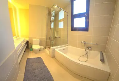 a bathroom with a tub and a shower and a toilet at El Gouna Cyan the Range 4BDs Villa with private Pool in Hurghada