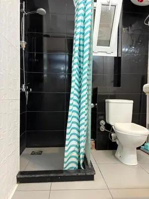 a bathroom with a toilet and a shower curtain at Amaizing 2BR Apartment B2 in Turtles Beach - Hurghada in Hurghada