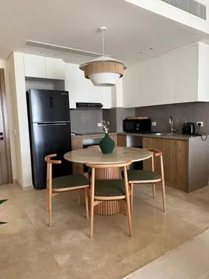 a kitchen with a table and chairs and a refrigerator at Ancient Sands Resort Gouna 1 Bedroom apartment with open view in Hurghada
