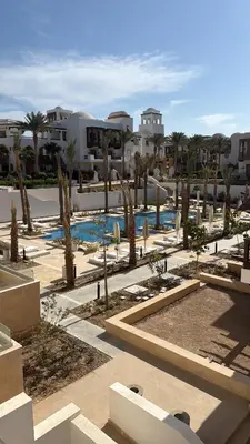 a resort with a pool and palm trees and buildings at Ancient Sands Resort Gouna 1 Bedroom apartment with open view in Hurghada