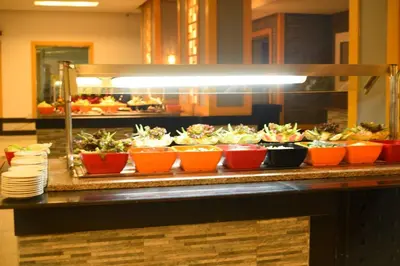 a buffet line with bowls of food on a counter at Chalets 980 in Mirage resort in Hurghada