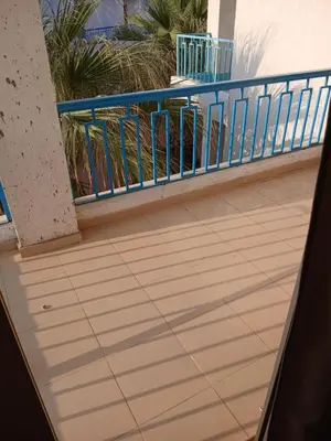 a balcony with a blue railing and palm trees at Chalets 980 in Mirage resort in Hurghada