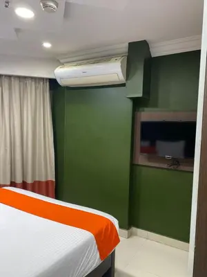 a room with a bed and a green wall at Nile Plaza Suites in Aswan