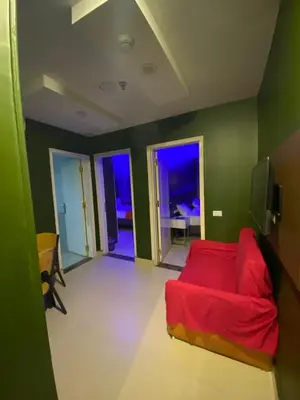a living room with a red couch and green walls at Nile Plaza Suites in Aswan