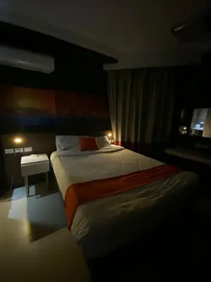 a bedroom with a large bed and a small table at Nile Plaza Suites in Aswan
