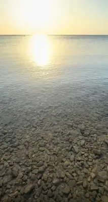 a body of water with the sun reflecting in the water at Cecelia Resort in Hurghada