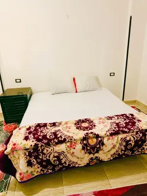a bed with a colorful blanket on top of it at Luxor Old nile apartment in Luxor
