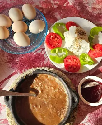 a table with eggs and vegetables and a bowl of dip at ARKN angel Nubian Guest House in Jazīrat al ‘Awwāmīyah
