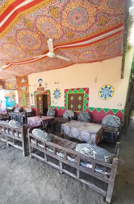 a room with couches and a colorful ceiling at ARKN angel Nubian Guest House in Jazīrat al ‘Awwāmīyah