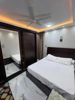 a bedroom with a large bed and a mirror at Flat in Nag` el-Ramla