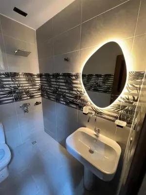 a bathroom with a sink and a mirror and a toilet at Aswan in Nag` el-Ramla