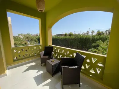 a balcony with two chairs and a large window at Casa Esmeralda in Hurghada