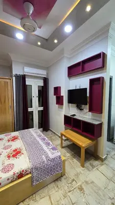 a bedroom with a bed and a flat screen tv at Saint charbel in Hurghada