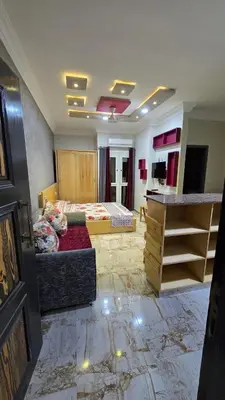 a large room with a bed and a desk in it at Saint charbel in Hurghada