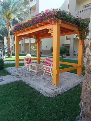 a gazebo with two chairs and a table with flowers at katakitu in Hurghada