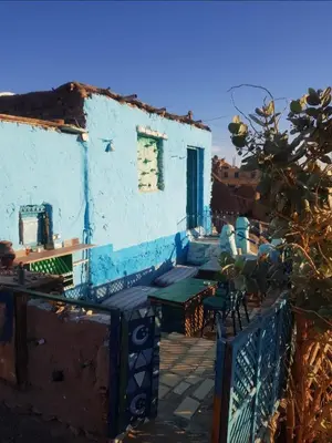 a blue building with tables and chairs in front of it at Seheil Antique House in Jazīrat Salūjah