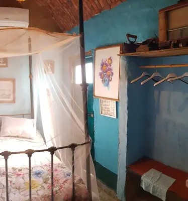 a bedroom with a canopy bed and a blue wall at Seheil Antique House in Jazīrat Salūjah