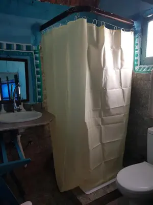 a bathroom with a shower curtain and a toilet at Seheil Antique House in Jazīrat Salūjah