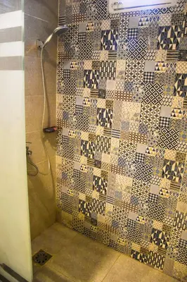 a bathroom with a shower with a tiled wall at Isis Magic House in Luxor
