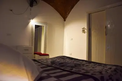 a bedroom with a bed with a dresser and a mirror at Isis Magic House in Luxor