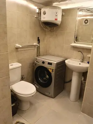 a washing machine in a bathroom with a toilet and a sink at فلورانزا خمسين b06 in Hurghada