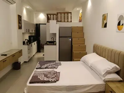 a bedroom with a bed and a kitchen with a refrigerator at فلورانزا خمسين b06 in Hurghada