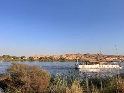 a white boat on the water on a river at Nile SE Felucca nile cruise private tour in Naj‘ al ‘Amrāb