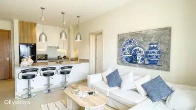 a living room with a white couch and a table at Ollystays Shedwan 2 BR Pool & lagoon access in Hurghada