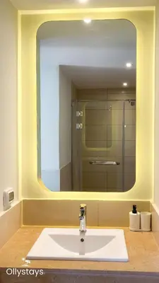 a bathroom with a sink with a large mirror at Ollystays Shedwan 2 BR Pool & lagoon access in Hurghada