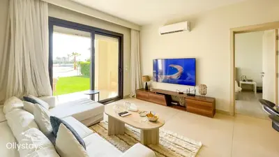 a living room with a white couch and a table at Ollystays Shedwan 2 BR Pool & lagoon access in Hurghada