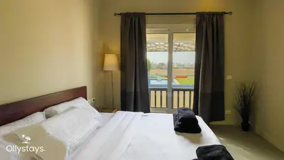 a bedroom with a bed with white sheets and a window at Ollystays Joubal Lagoon 3BR Villa Heated Pool in Hurghada