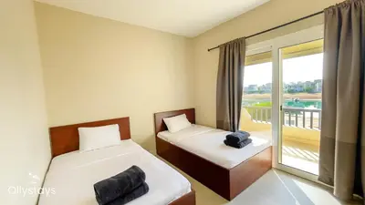 two beds in a room with a balcony at Ollystays Joubal Lagoon 3BR Villa Heated Pool in Hurghada