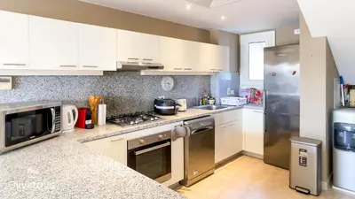 a kitchen with white cabinets and stainless steel appliances at Ollystays Joubal Lagoon 3BR Villa Heated Pool in Hurghada