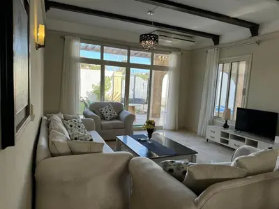 a living room with couches and a table and a tv at Luxury Red Sea Villa in Hurghada