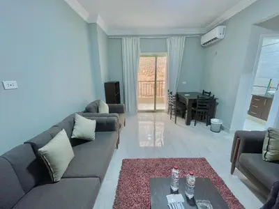 a living room with two couches and a table in it at Elegant one bedroom apartment managed by Lilly Homes in Hurghada