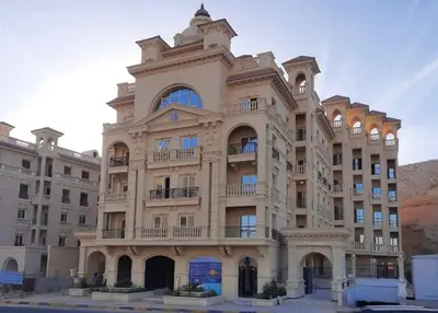 a large tan building with a balcony at Elegant one bedroom apartment managed by Lilly Homes in Hurghada