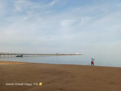 a man standing on the beach near a pier at Palma Resort Apartments and Suites with Private Beach in Hurghada