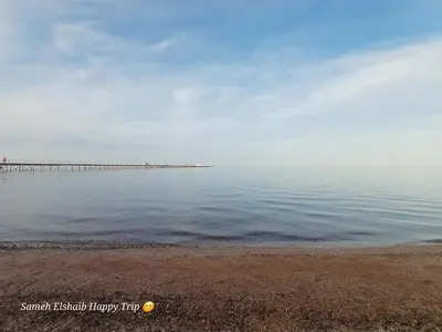a large body of water with a pier in the background at Palma Resort Apartments and Suites with Private Beach in Hurghada