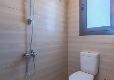 a bathroom with a shower with a toilet and a window at Ollystays Ancient Hill 4BR Villa Private Pool in Hurghada
