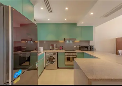 a kitchen with green cabinets and a washing machine at Ollystays Ancient Hill 4BR Villa Private Pool in Hurghada