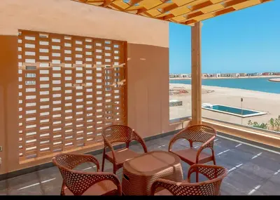 a table and chairs in a room with a view of a beach at Ollystays Ancient Hill 4BR Villa Private Pool in Hurghada