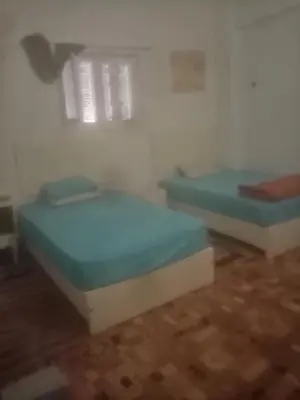 two beds sitting in a room with wooden floors at New senger tood in Naj‘ al ‘Amrāb