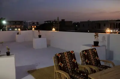 two chairs sitting on a rooftop at night at Akhet House in Luxor