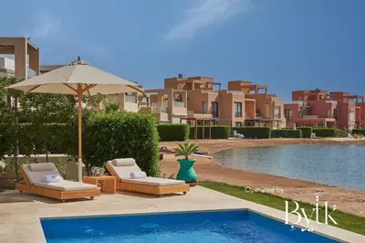 a swimming pool with two lounge chairs and an umbrella at BYTK - Casa De Familia in Hurghada