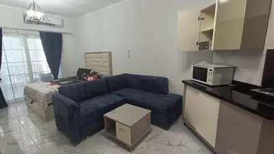 a living room with a blue couch and a bed at Juliana beach resort in Hurghada