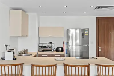 a kitchen with a counter with chairs and a refrigerator at The G Cribs Sunlit - El Gouna in El Gouna