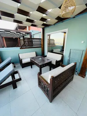 a living room with a table and chairs on a balcony at New Marina Apartments in Hurghada