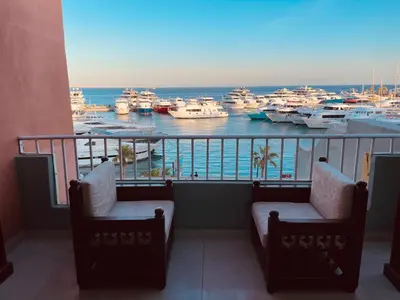 a balcony with two chairs and a marina with boats at New Marina Apartments in Hurghada